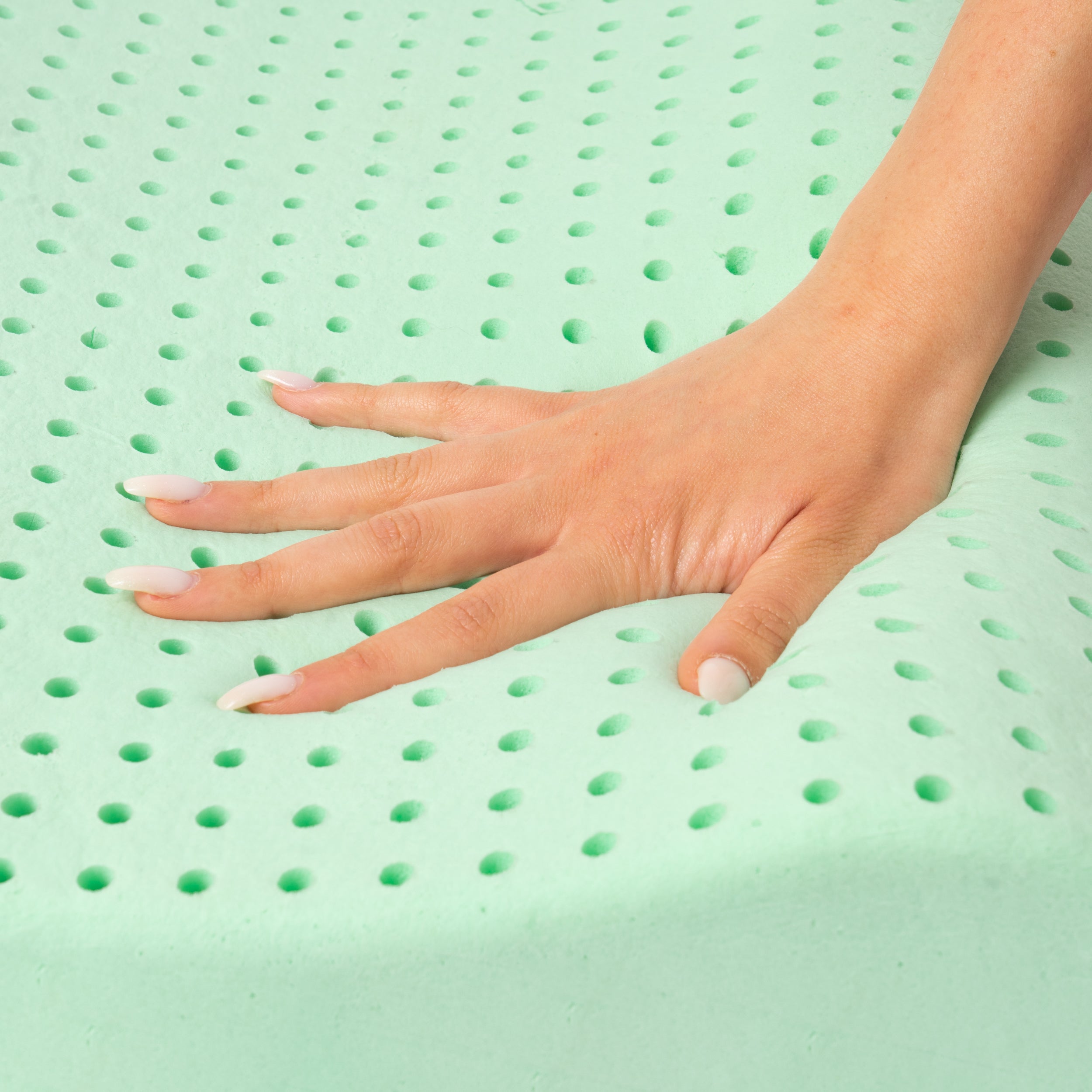 Una mano preme su una superficie verde forata.