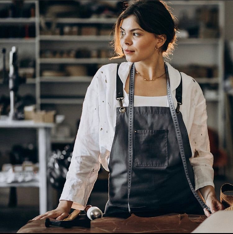 Donna con grembiule e metro in una bottega.