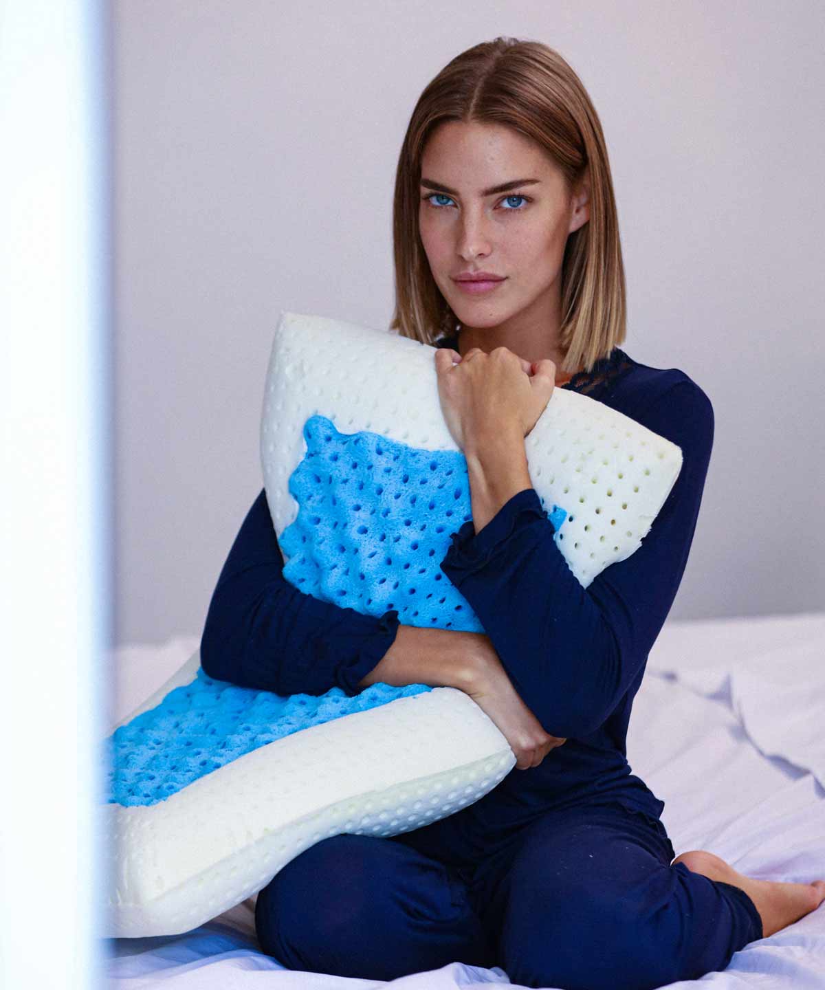 Donna abbraccia un cuscino bianco e blu.