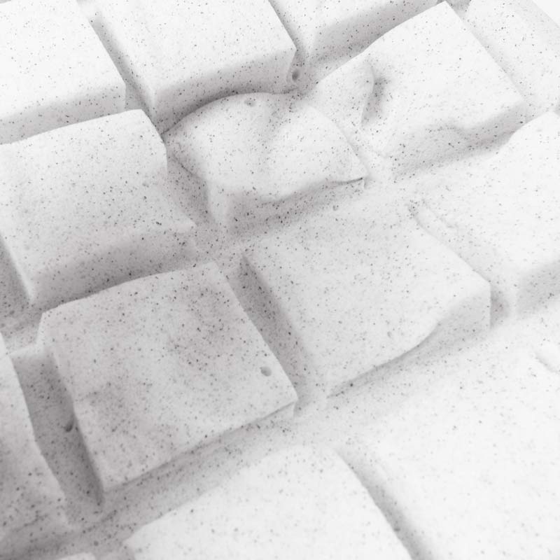 Superficie imbottita bianca con motivi quadrati in rilievo.