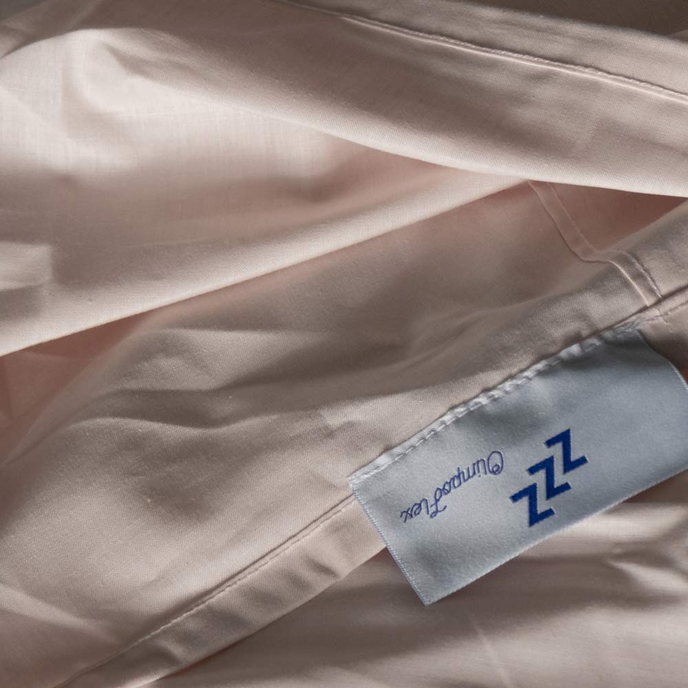 Etichetta blu su tessuto beige chiaro.